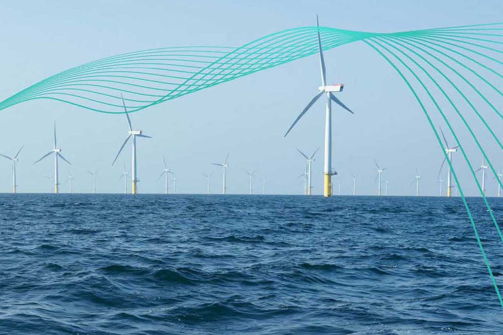 Farm wiatrowy na morzu z wieloma turbinami wiatrowymi prodującymi energię odnawialną, w tle jasne, niebieskie niebo.