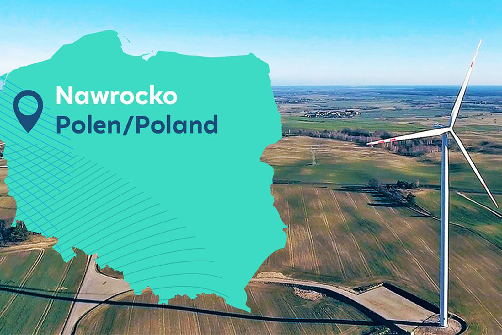 Aerial view of Nawrocko, Poland, featuring a wind turbine against a backdrop of green fields and a clear blue sky.