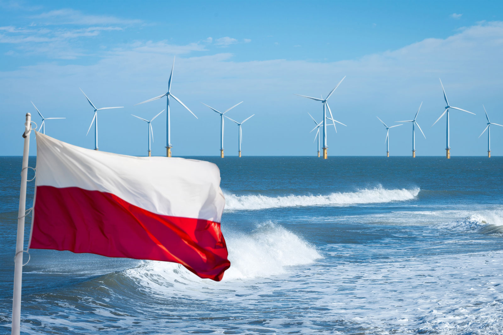 The Polish flag flutters in front of a coastal landscape with wind turbines in the background and waves in the foreground.